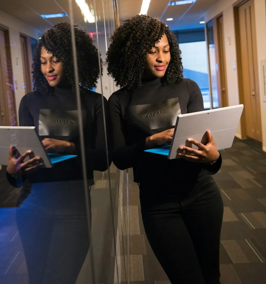A woman reading on a tablet in a modern office
