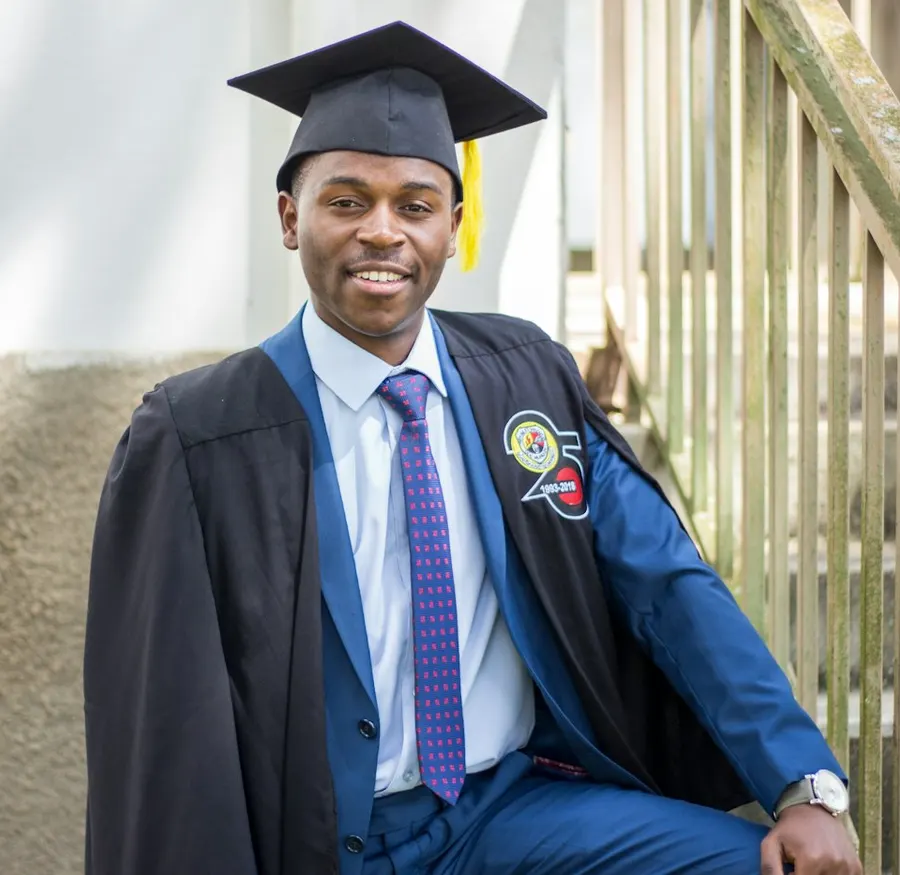 A smiling graduate in cap and gown